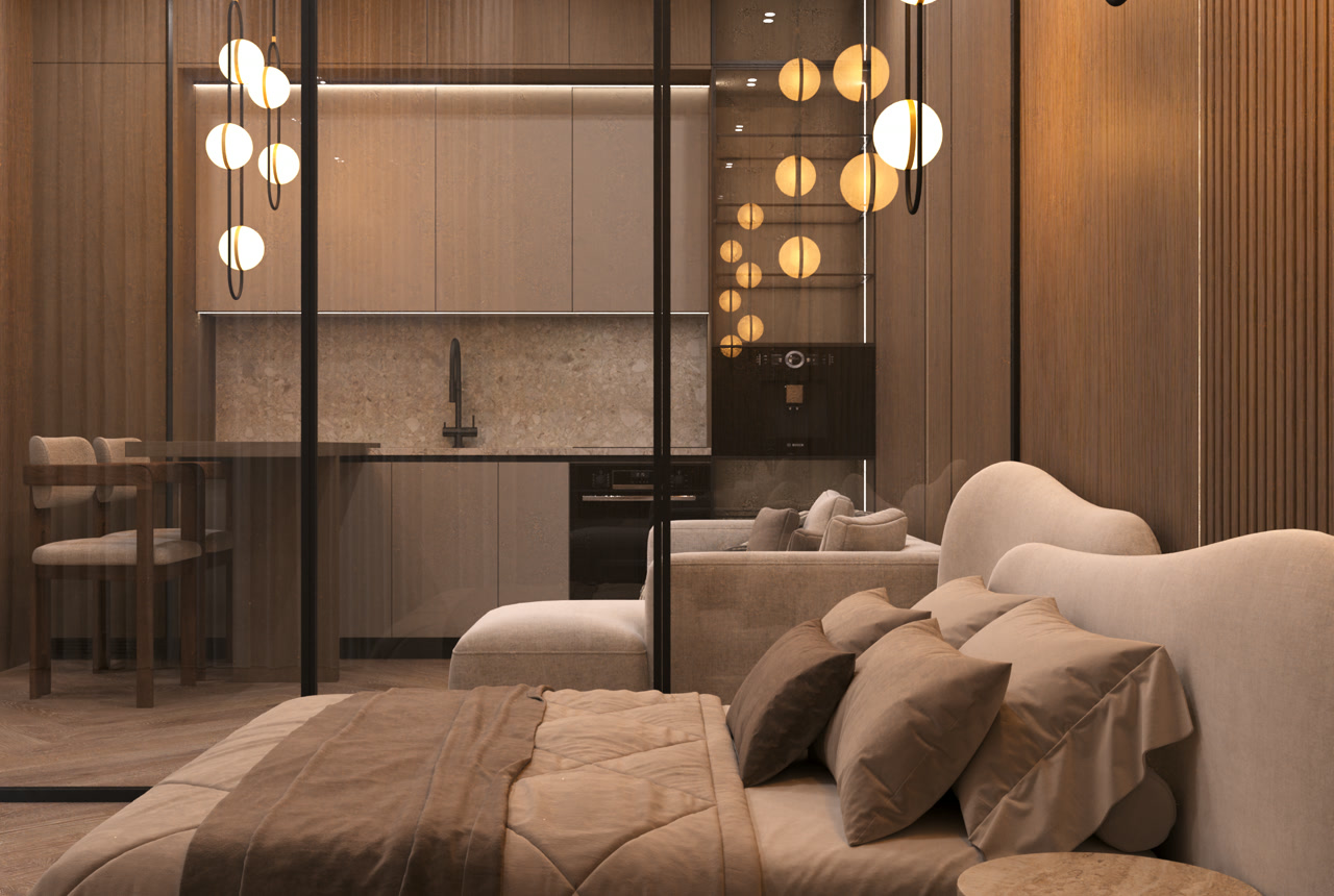 Studio with the bed in the foreground and, behind a glass partition, the kitchen and living area with pendant lights