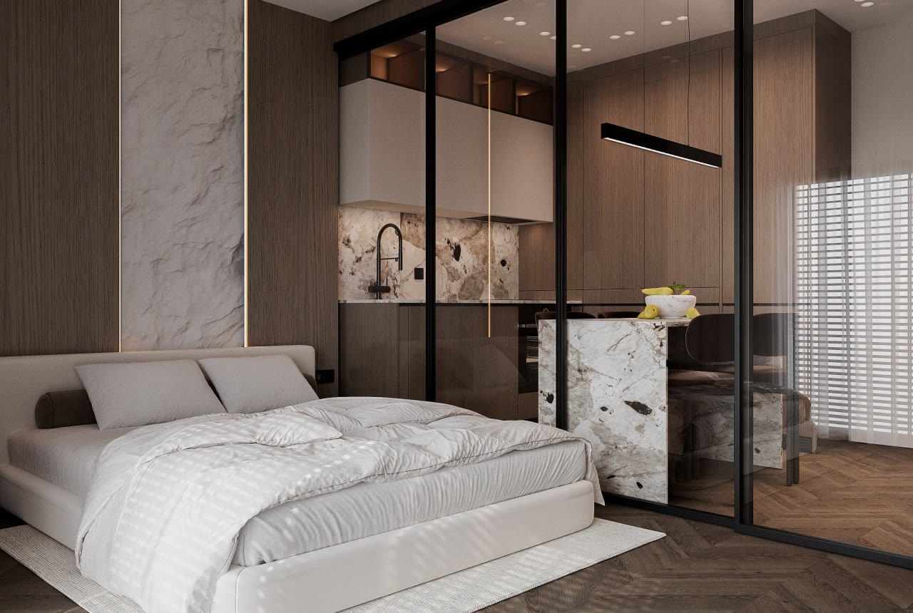 Studio in the second layout: light bed and a marble kitchen island behind glass partitions